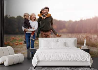 Happy young family in pumpkin patch field Wall mural