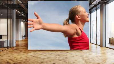 happy young woman with arms outstretched Wall mural