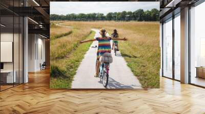 Little girl riding a bicycle with her arms outstretched 
 Wall mural