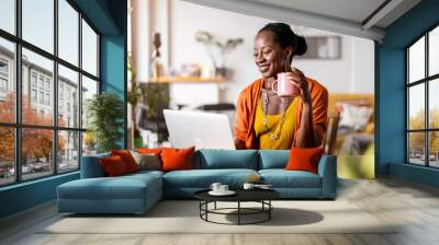 Mature woman working on laptop at home
 Wall mural