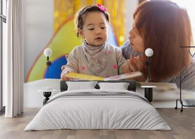 Mother and daughter reading a book together Wall mural