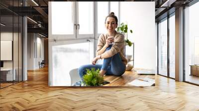 Portrait of a smiling creative woman in a modern loft space
 Wall mural