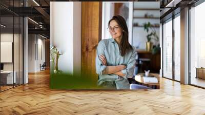 Portrait of a young woman standing in her home
 Wall mural