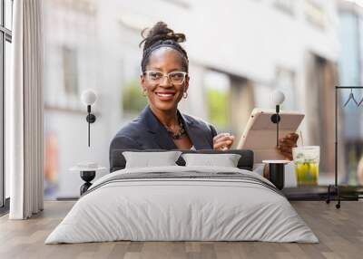 Portrait of happy businesswoman using tablet computer in outdoor cafe
 Wall mural