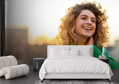 Portrait of young woman with curly hair in the city
 Wall mural