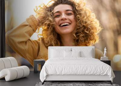 Portrait of young woman with curly hair in the city
 Wall mural