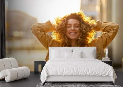 Portrait of young woman with curly hair in the city
 Wall mural