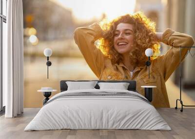 Portrait of young woman with curly hair in the city
 Wall mural