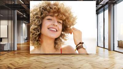 Portrait of young woman with curly hair Wall mural