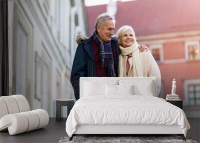 Senior couple walking on the city street at winter day Wall mural