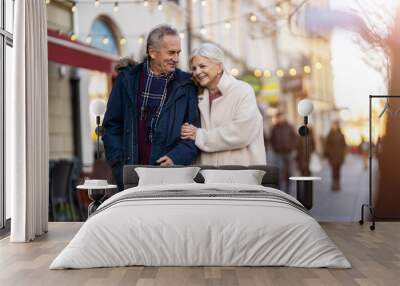 Senior couple walking on the city street at winter day Wall mural