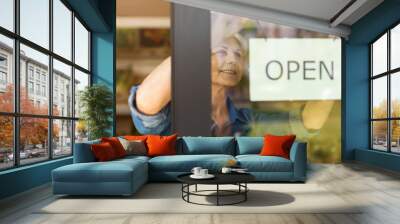 Senior woman holding open sign in organic produce shop Wall mural