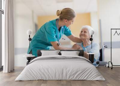 Senior woman in wheelchair with nurse in hospital Wall mural