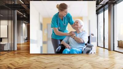 Senior woman in wheelchair with nurse in hospital Wall mural