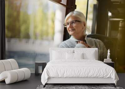 Senior Woman Looking Through Window While Traveling In Bus
 Wall mural