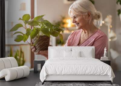 Senior woman taking care of her potted plants at home Wall mural