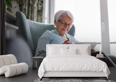 Senior woman using a digital tablet at home
 Wall mural