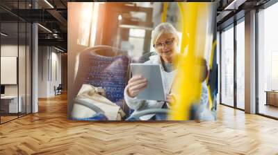 Senior woman using tablet, while riding public bus
 Wall mural