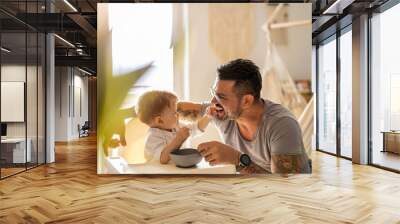 Single dad feeding his baby 
 Wall mural