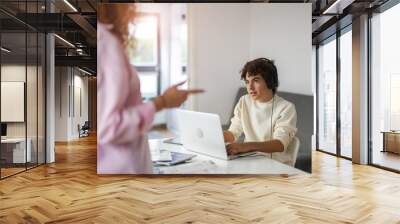 Teenage boy playing video games while his mother is not happy about it Wall mural