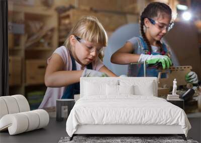 Two young girls doing woodwork in a workshop
 Wall mural