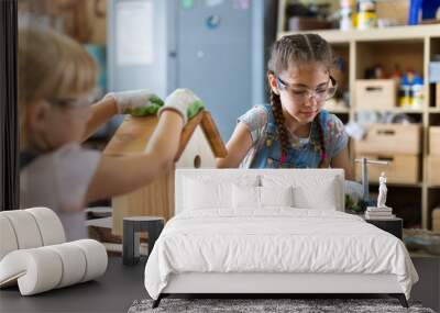 Two young girls doing woodwork in a workshop
 Wall mural