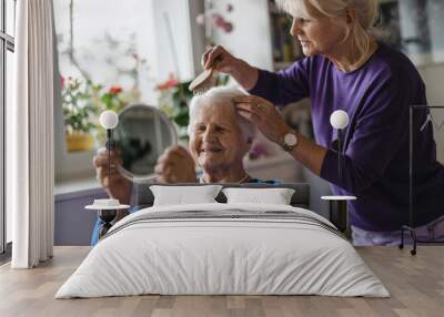 Woman combing hair of elderly mother 
 Wall mural