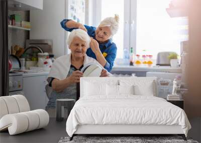 Woman cutting her elderly mother's hair at home
 Wall mural