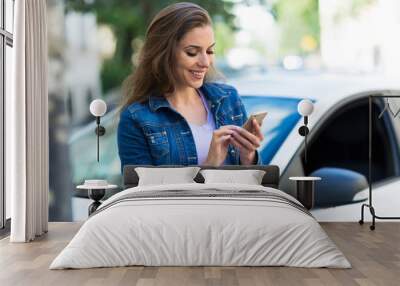 Woman using mobile phone near car
 Wall mural