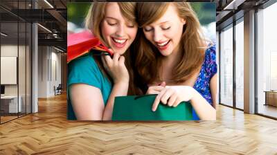 Women looking in shopping bags Wall mural