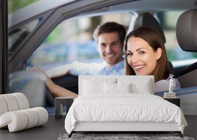 young couple sitting in car Wall mural