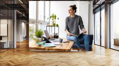 Young female freelancer working in loft office
 Wall mural