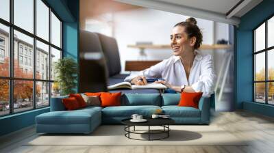 Young female freelancer working in loft office
 Wall mural