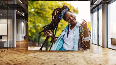 Young woman enjoying dancing and listening music outdoors
 Wall mural