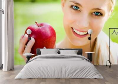 Young woman holding apple, smiling Wall mural