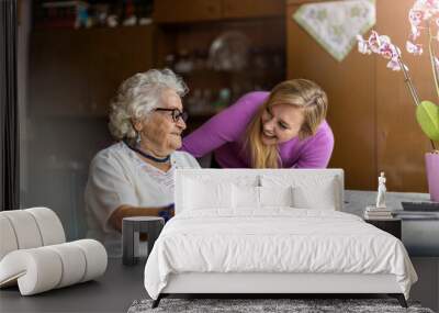 Young woman spending time with her elderly grandmother at home
 Wall mural