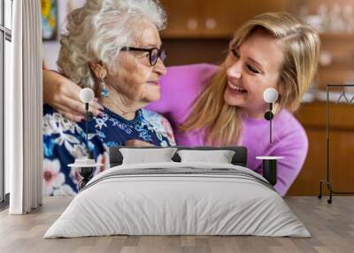 Young woman spending time with her elderly grandmother at home
 Wall mural