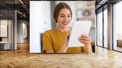 Young woman using digital tablet at home Wall mural