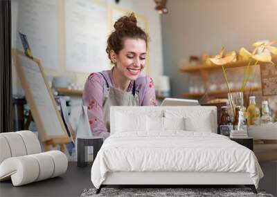 Young woman using digital tablet in coffee shop Wall mural