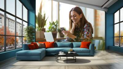 Young woman with laptop in cafe Wall mural