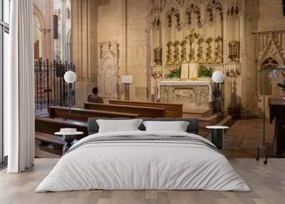 Woman praying in interior of church in Lyon in France Wall mural