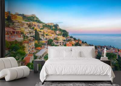 Aquamarine blue waters of  sea and fantastic cityscape of Taormina during sunset Wall mural