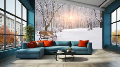 snow-covered trees and benches in the city park Wall mural