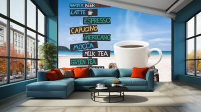 coffee cup and wooden signpost with name of coffee and soft drink on sand beach over blurred tropical blue sea on day noon light. Wall mural