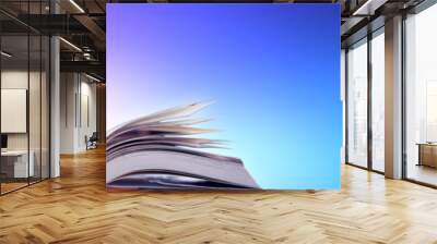 Book in library with old open textbook, stack piles of literature text archive on reading desk, and aisle of bookshelves in school study class room background for academic education learning concept Wall mural