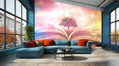 education concept with tree of knowledge planting on opening old big book in library with textbook, stack piles of text archive and aisle of bookshelves in school study class room Wall mural