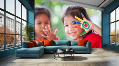 Cute asian little child girl with painted hands smiling with fun and happiness Wall mural