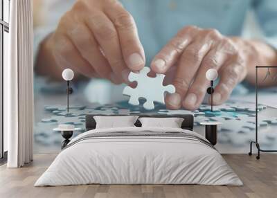 Close-up of a person assembling puzzle pieces, focusing on one piece in hand, symbolizing problem-solving, teamwork, and strategy. Wall mural