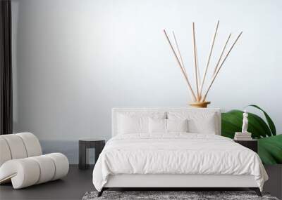 aroma reed diffuser home fragrance with rattan sticks on a light background with palm leaves and shadows. Wall mural