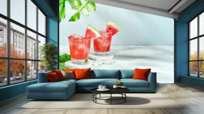 Fresh drink with watermelon and mint, cold summer lemonade, healthy mocktail. Sunny day shadows on blue sky background with copy space. Layout for wide banner. Wall mural